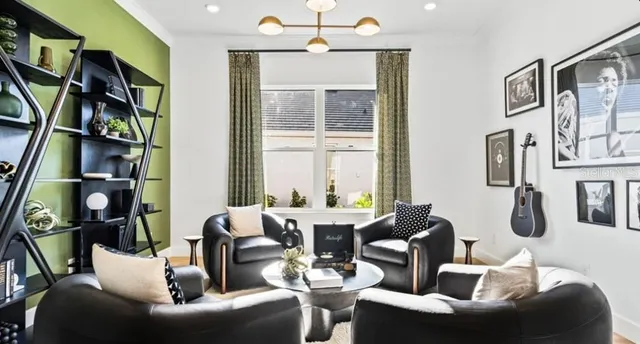 a living room with furniture a bookshelf and a large window
