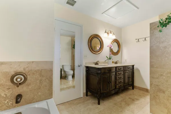 a spacious bathroom with a granite countertop sink and a mirror