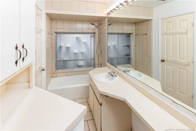 a bathroom with a tub sink and mirror