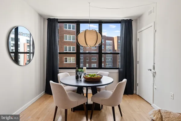a living room with furniture a mirror a lamp and a flat screen tv