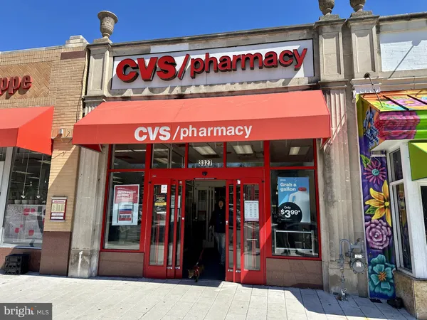 a front view of multi story residential apartment building with yard and retail shops