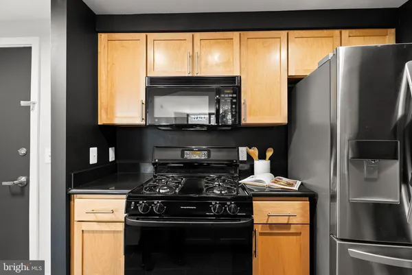 a kitchen with granite countertop a sink stainless steel appliances and cabinets