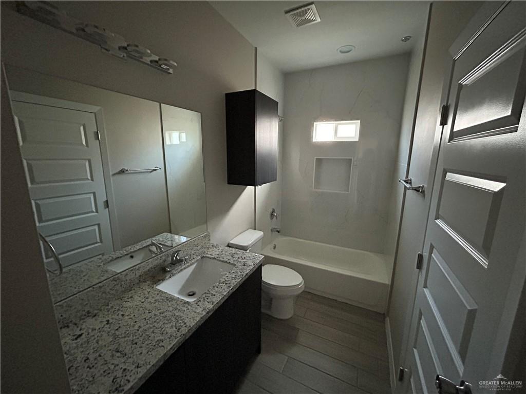 5705 Puffin Avenue, Unit 1 Mission, TX 78573 - Photo 11 of 16 a bathroom with a granite countertop sink and a mirror