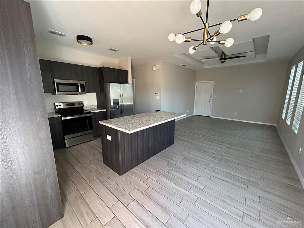 5705 Puffin Avenue, Unit 1 Mission, TX 78573 - Photo 6 of 16 a large kitchen with stainless steel appliances a large counter top a sink a stove and a refrigerator