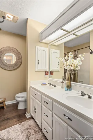 a bathroom with a double vanity sink mirror and toilet