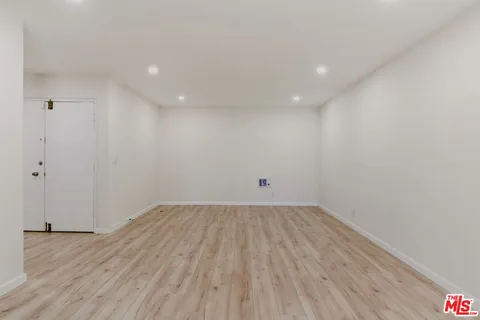 a view of a room with wooden floor and white walls
