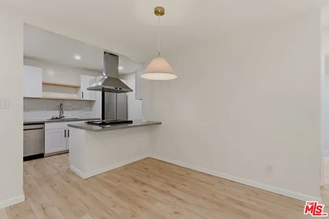 a kitchen with a sink cabinets and wooden floor