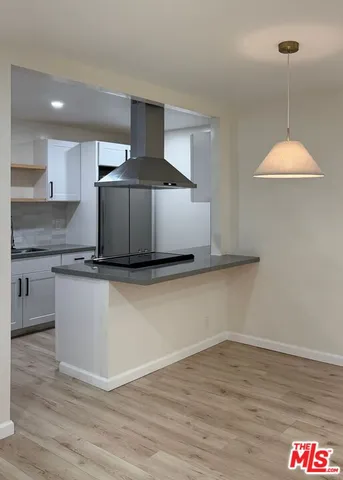 a kitchen with a sink cabinets and wooden floor