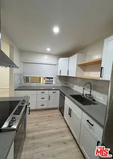 a kitchen with stainless steel appliances granite countertop a sink stove and cabinets