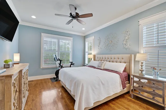 a bedroom with a large bed a flat tv screen and a dresser