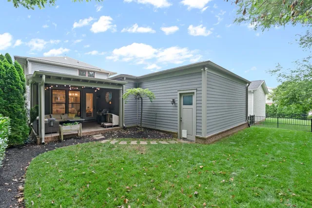 a view of a backyard with plants and large tree