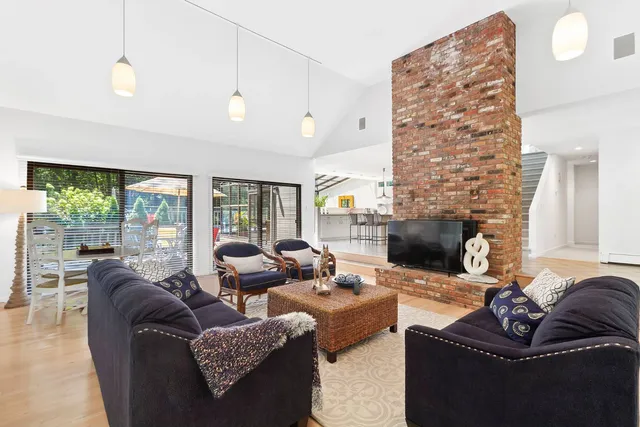 a living room with furniture fireplace and a large window