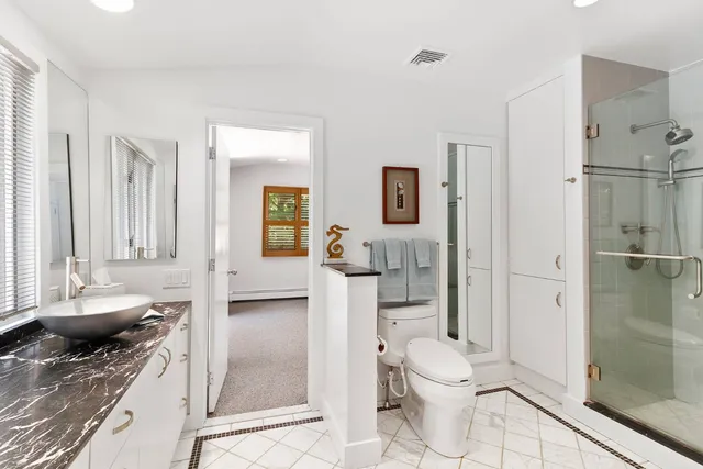 a bathroom with a granite countertop sink toilet and shower