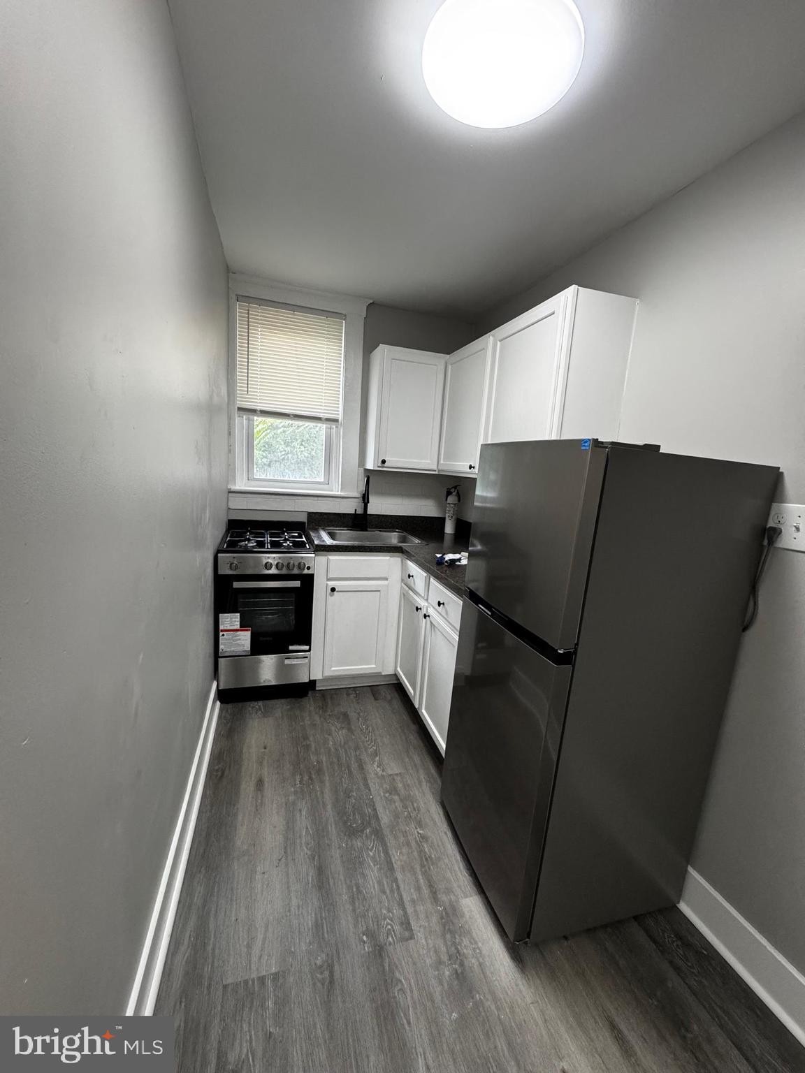 2656 Shields Street Philadelphia, PA 19142 - Photo 6 of 15 a kitchen with wooden cabinets and a sink