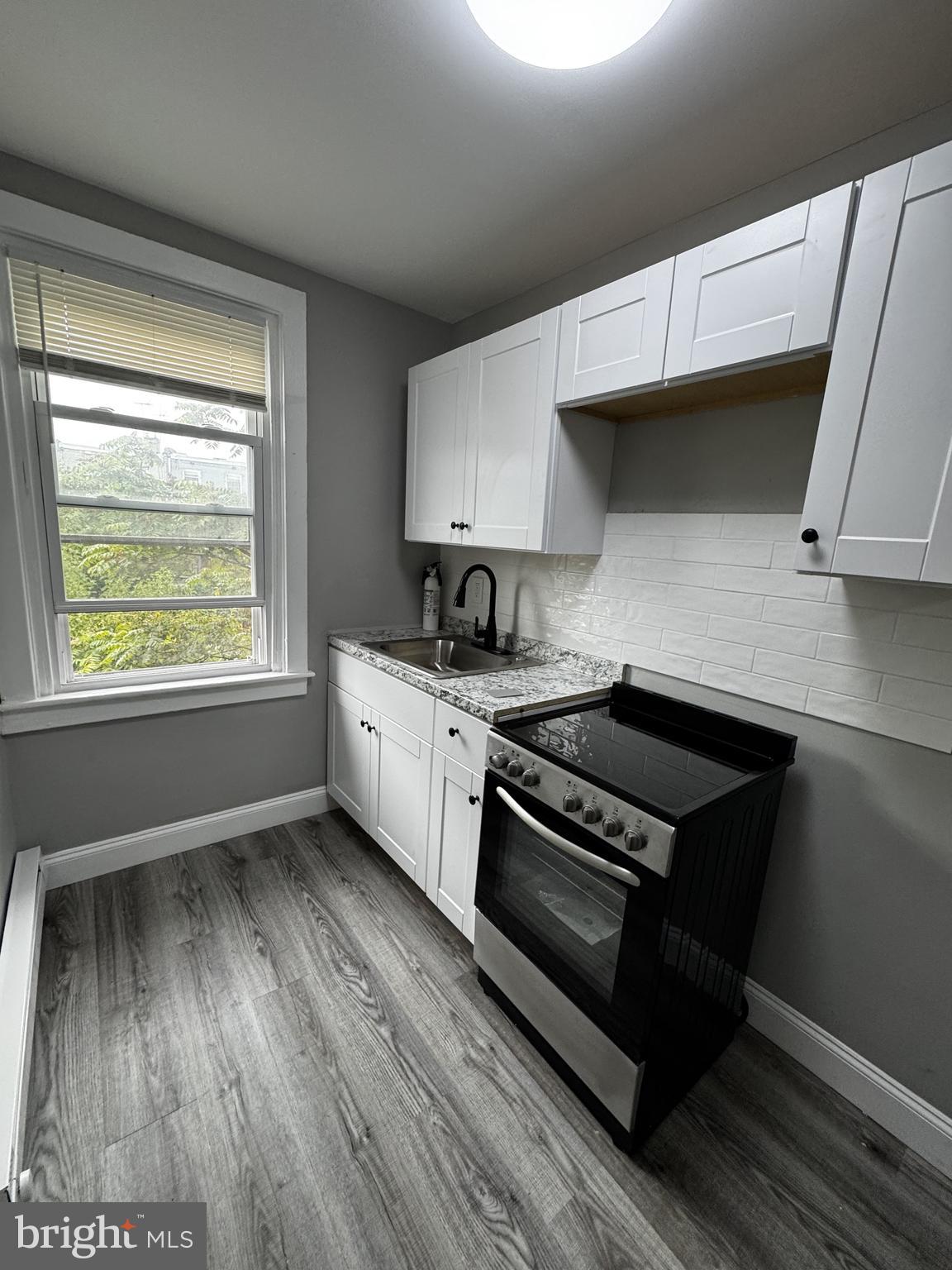 2656 Shields Street Philadelphia, PA 19142 - Photo 10 of 15 a kitchen with granite countertop wooden floors and a stove