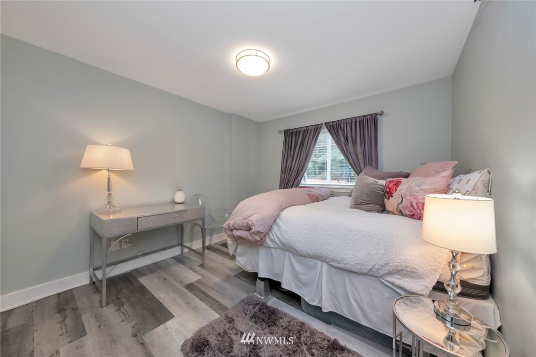 455 Newport Way Northwest, Unit 302 Issaquah, WA 98027 - Photo 11 of 17 a bedroom with a bed and a lamp