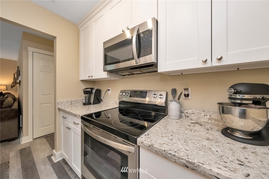 455 Newport Way Northwest, Unit 302 Issaquah, WA 98027 - Photo 4 of 17 a kitchen with stainless steel appliances granite countertop a stove and a microwave