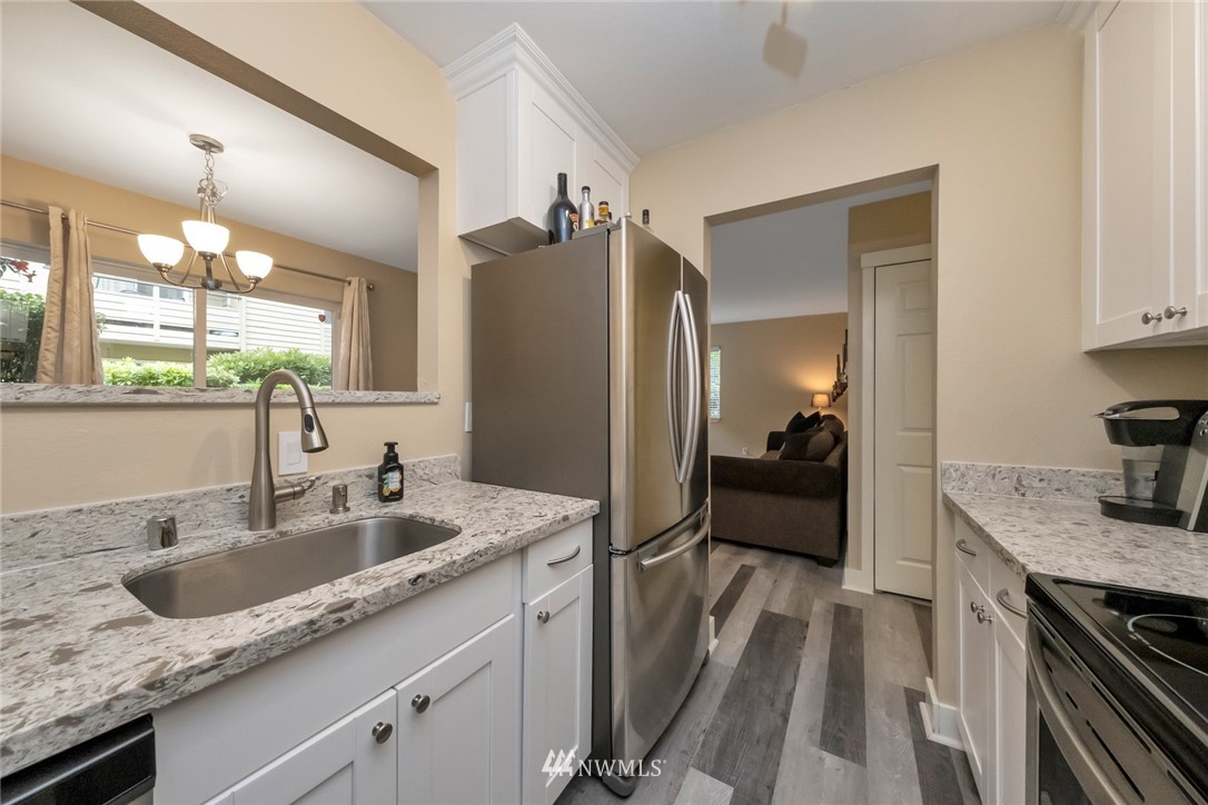 455 Newport Way Northwest, Unit 302 Issaquah, WA 98027 - Photo 5 of 17 a en suite bathroom with a granite countertop sink and a large mirror