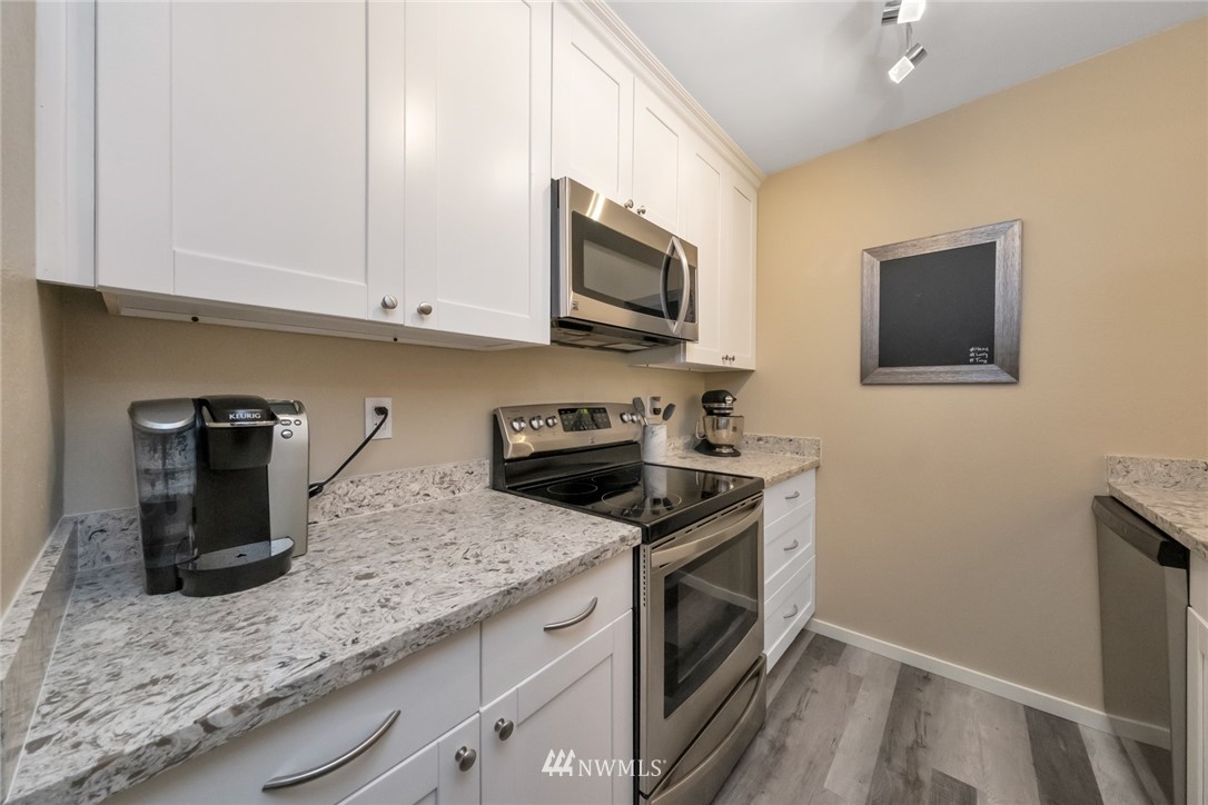 455 Newport Way Northwest, Unit 302 Issaquah, WA 98027 - Photo 6 of 17 a kitchen with stainless steel appliances granite countertop a sink stove and microwave