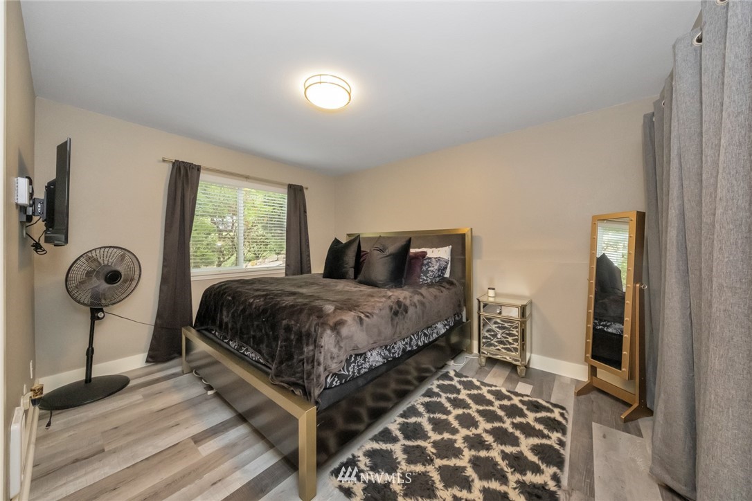 455 Newport Way Northwest, Unit 302 Issaquah, WA 98027 - Photo 9 of 17 a bedroom with a bed and a chandelier