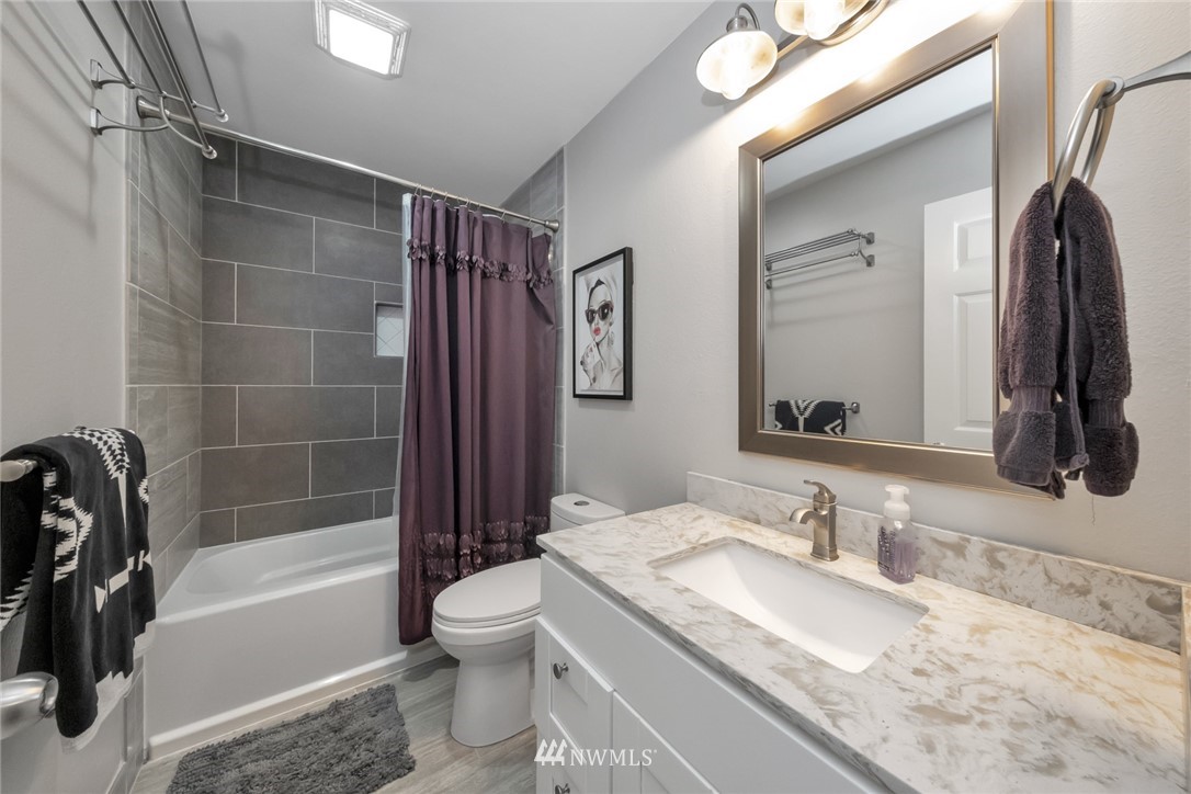455 Newport Way Northwest, Unit 302 Issaquah, WA 98027 - Photo 10 of 17 a bathroom with a granite countertop sink toilet and shower