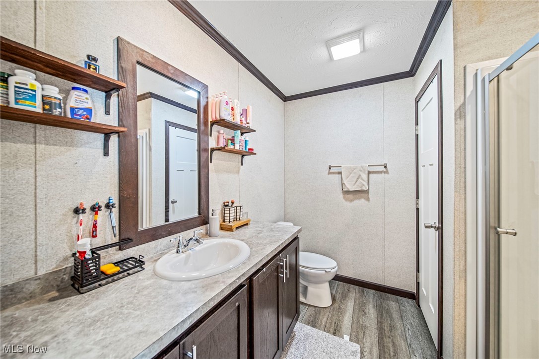 202 West Main Road, Unit LOT 13 Conneaut, OH 44030 - Photo 21 of 23 Full bathroom with ornamental molding, wood finished floors, vanity, a textured ceiling, and a shower with door