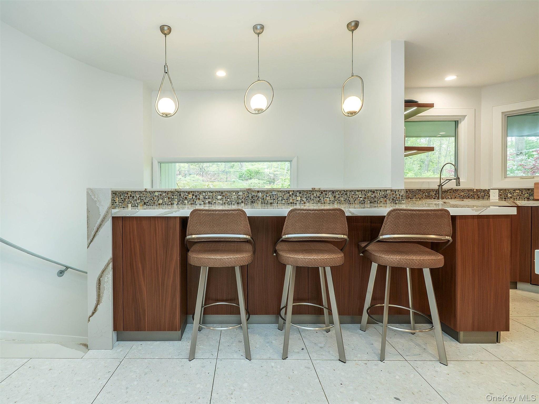 7 SE Road Sands Point, NY 11050 - Photo 18 of 45 a kitchen with a dining table chairs and white cabinets
