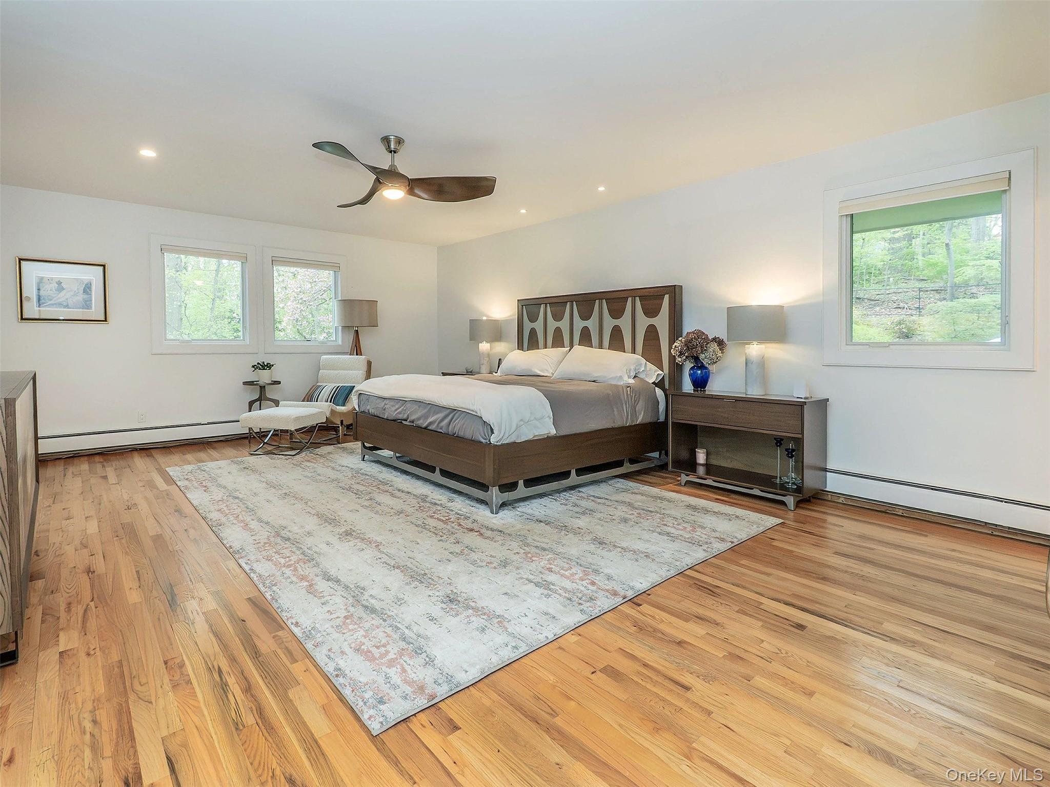 7 SE Road Sands Point, NY 11050 - Photo 20 of 45 a spacious bedroom with a bed and wooden floor
