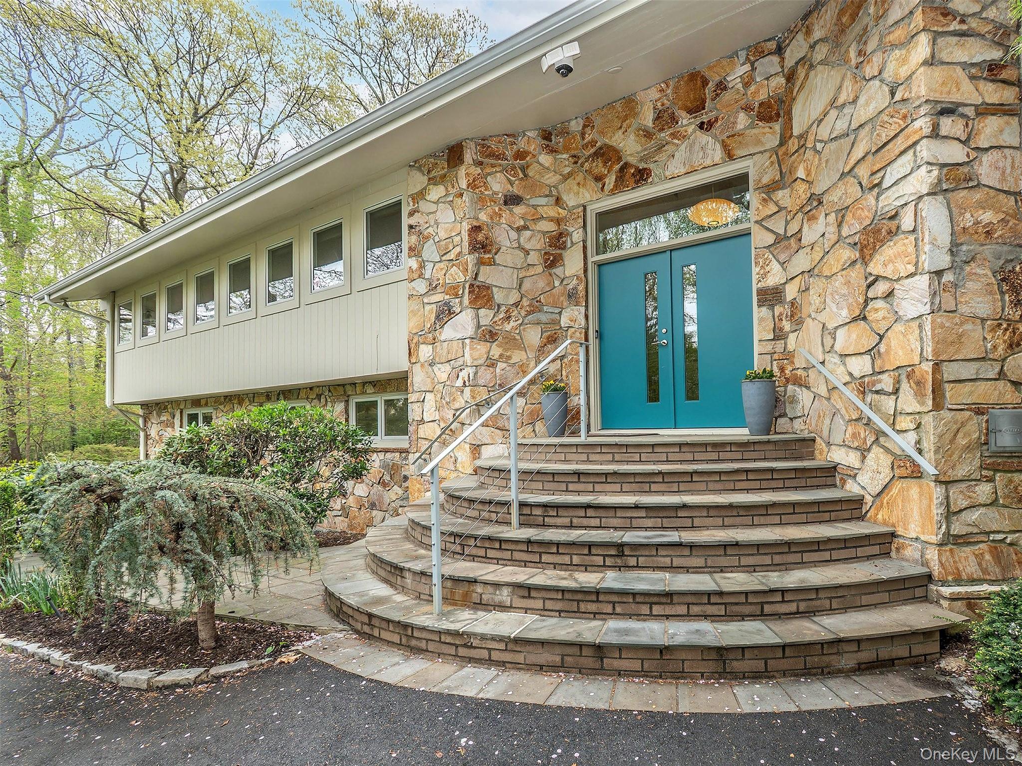 7 SE Road Sands Point, NY 11050 - Photo 2 of 45 a front view of a house with a garden