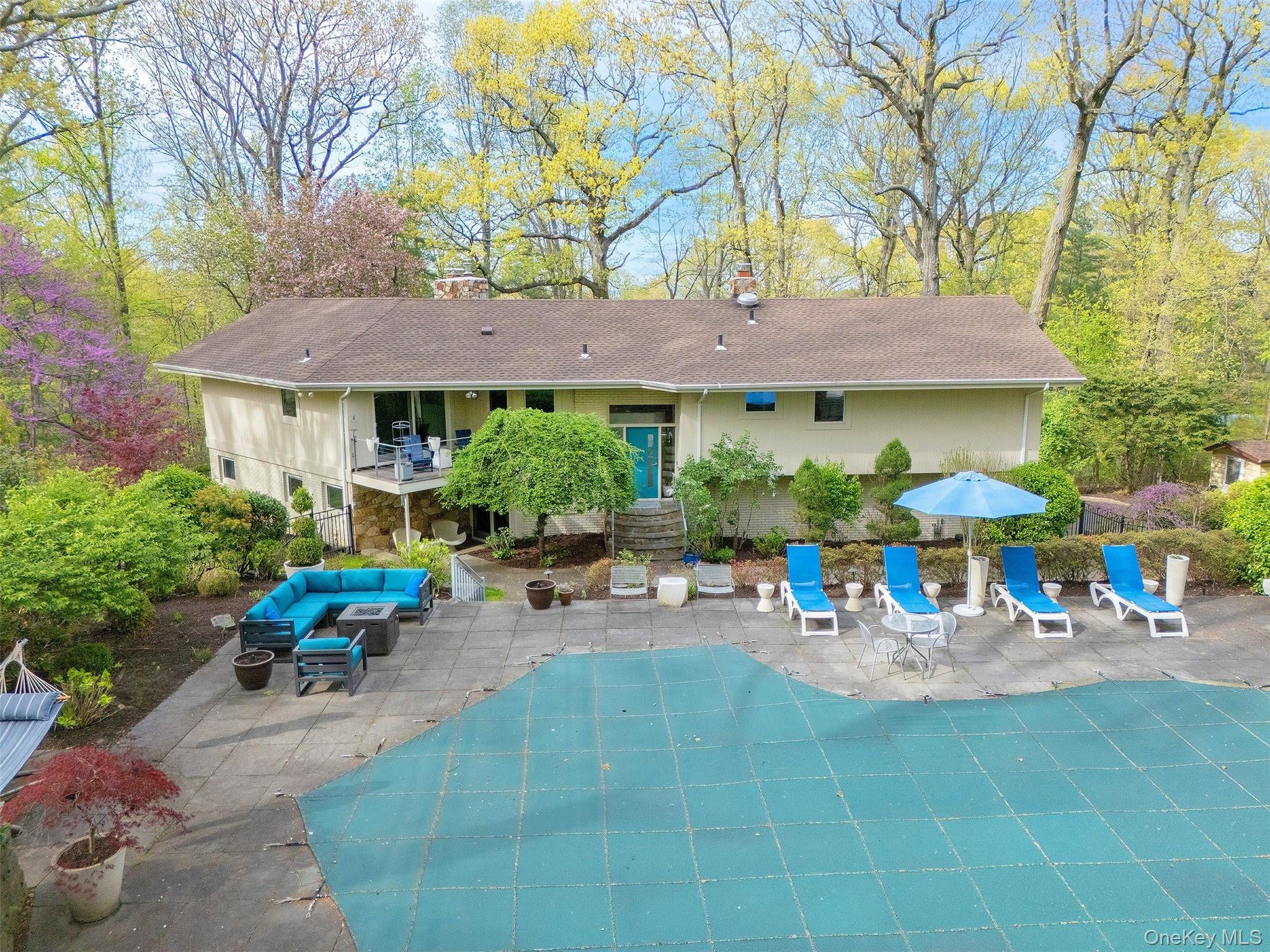 7 SE Road Sands Point, NY 11050 - Photo 42 of 45 a backyard of a house with table and chairs under an umbrella