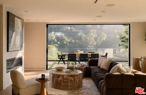 a living room with fireplace furniture and a large window