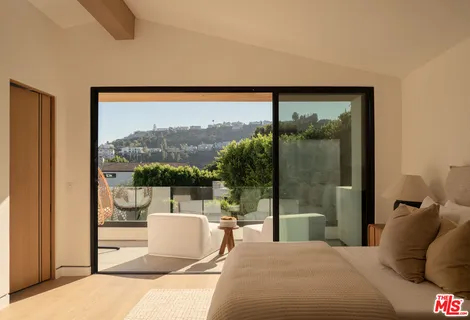 a living room with a floor to ceiling window and a flat screen tv