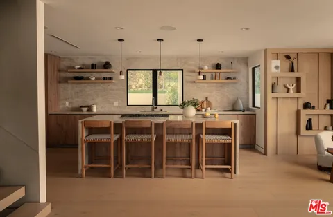a kitchen with kitchen island granite countertop a sink cabinets and stainless steel appliances