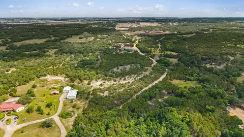 an aerial view of residential houses with outdoor space and trees