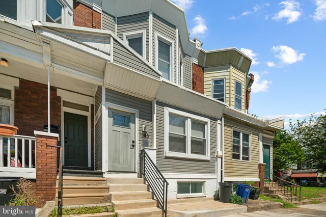 a front view of a house with a tree