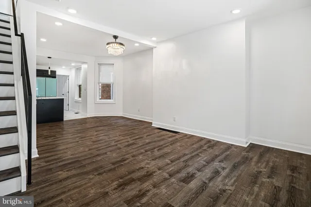 an empty room with wooden floor and a bathroom