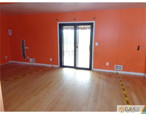 7504 Hana Road Edison, NJ 08817 - Photo 3 of 10 a view of an empty room with wooden floor and a window