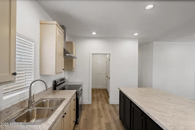 a kitchen with stainless steel appliances granite countertop a sink stove and refrigerator