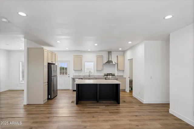 a view of kitchen with kitchen island wooden floor center island and stainless steel appliances