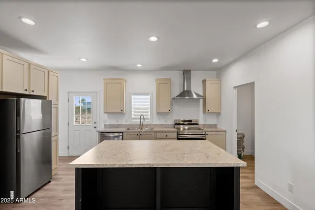 a view of kitchen with stainless steel appliances granite countertop a refrigerator and a stove top oven