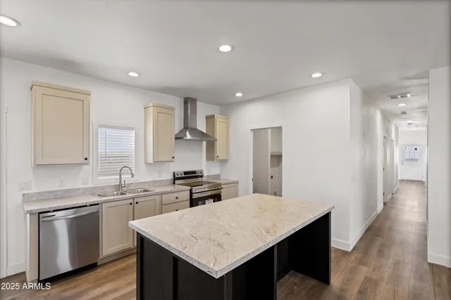 a kitchen with kitchen island a sink stove and refrigerator