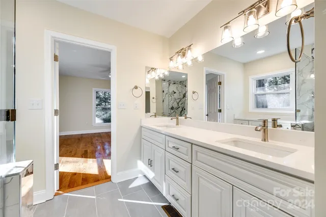 a bathroom with a double vanity sink mirror and bathtub
