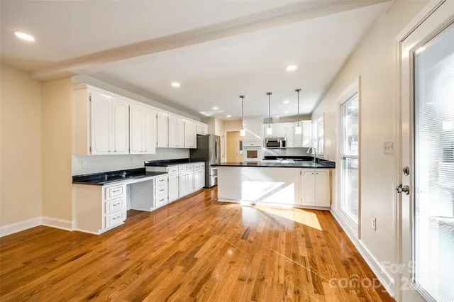 a kitchen with granite countertop a stove top oven and cabinets
