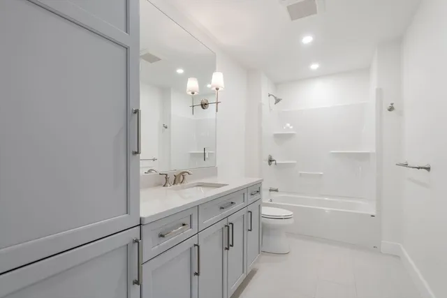 a bathroom with a double vanity sink toilet mirror and shower