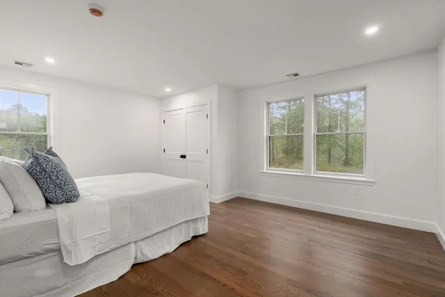 a bedroom with a bed and a large window