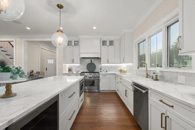 a large kitchen with stainless steel appliances granite countertop a sink stove and cabinets