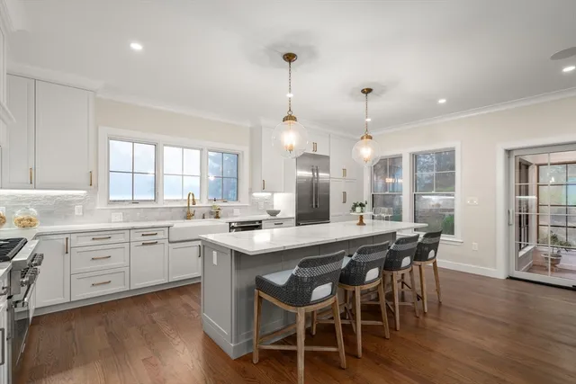 a kitchen with a dining table chairs wooden floor and appliances