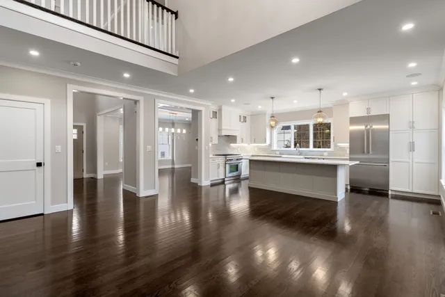 a living room with stainless steel appliances kitchen island wooden floors and view living room