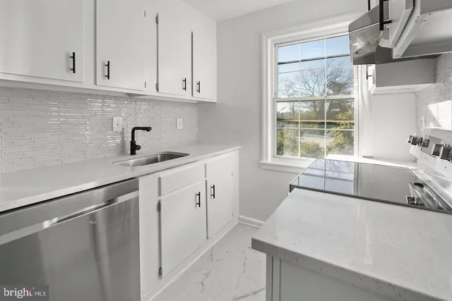 a kitchen with a sink window and cabinets
