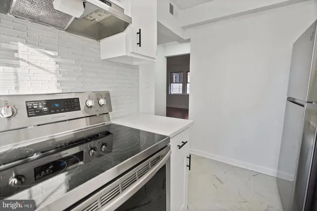 a stove top oven sitting inside of a kitchen